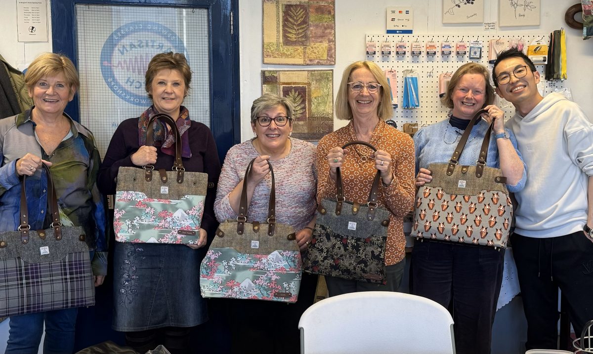 Bag-making with Oskar. Image shows 5 students proudly holding the bags they made